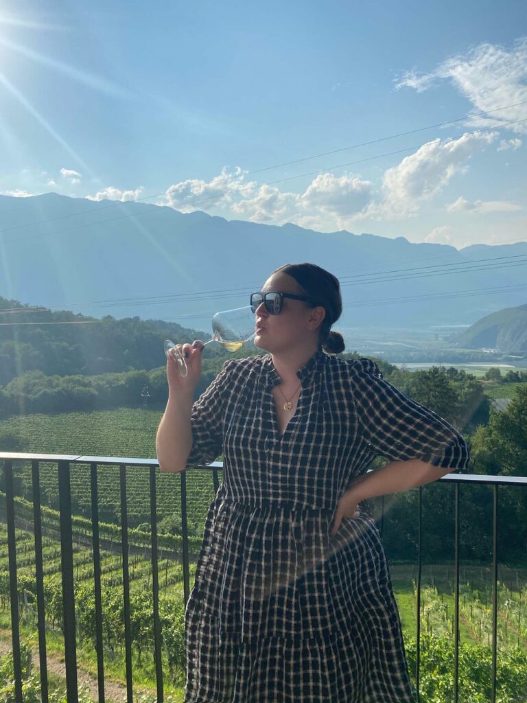 Frau trinkt auf Weingut mit Panorama Wein